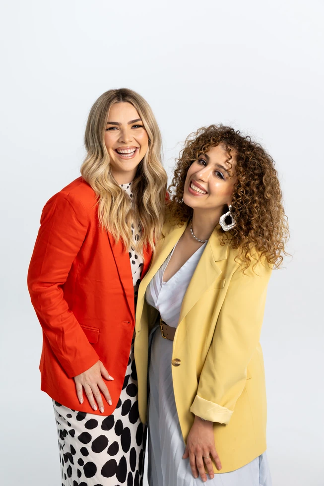 golden-edit-about-3 Two people smiling in colorful blazers styled for Golden Edit campaign