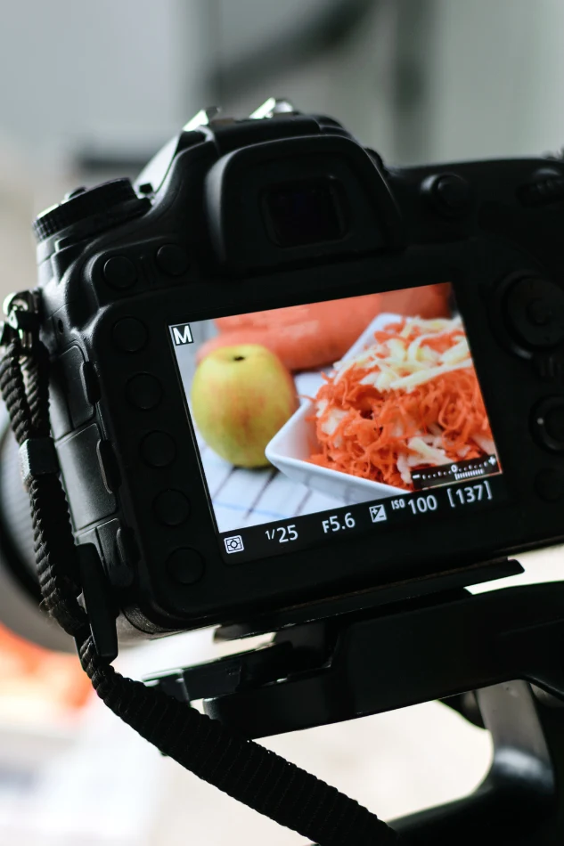 Product photographers capturing styled food imagery with professional camera gear for content marketing and digital menus.