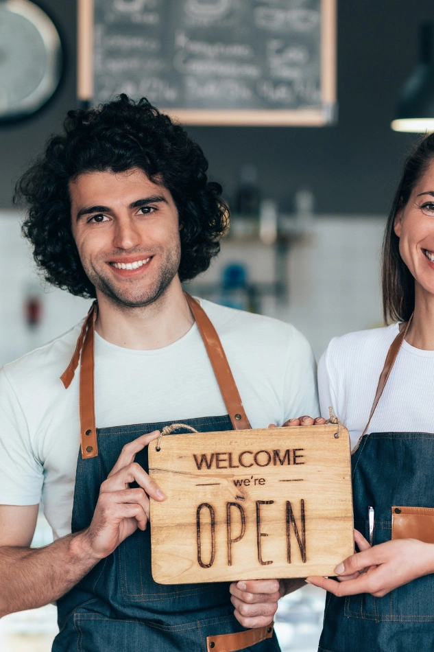 Portrait of a business owner holding open sign, perfect for a business photographer shoot
